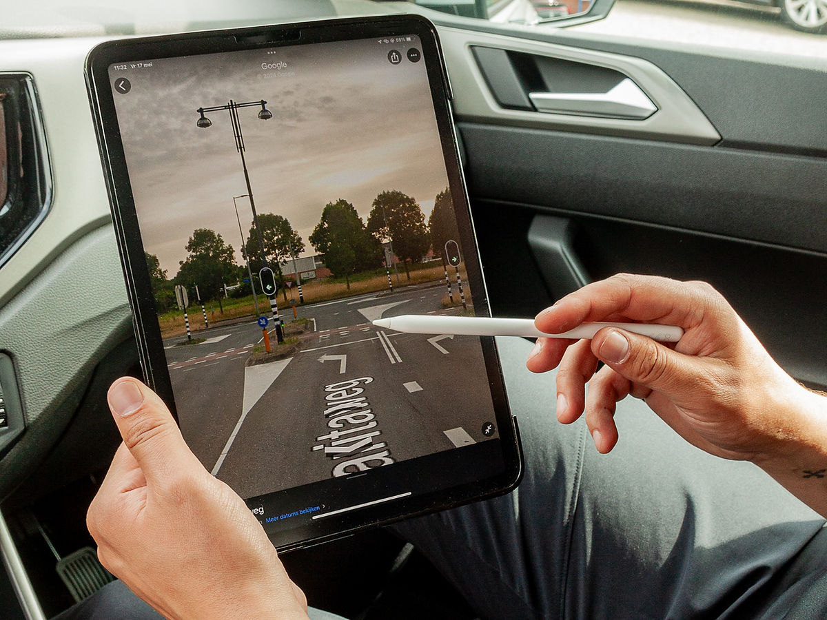 Uitleg van een verkeerssituatie op de tablet in de lesauto